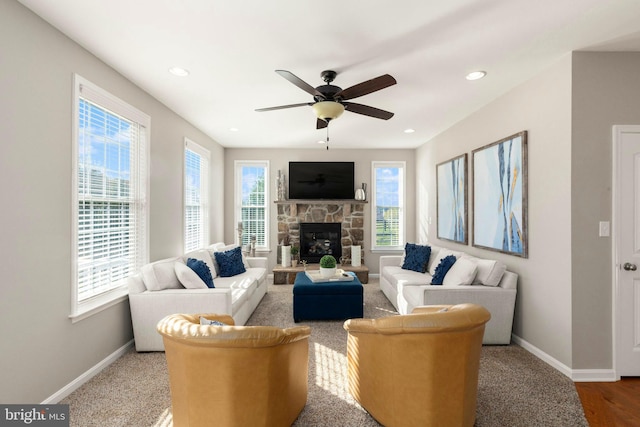 living room featuring a fireplace, ceiling fan, and a healthy amount of sunlight