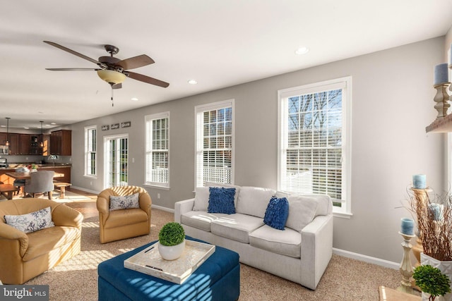 carpeted living room with a wealth of natural light and ceiling fan