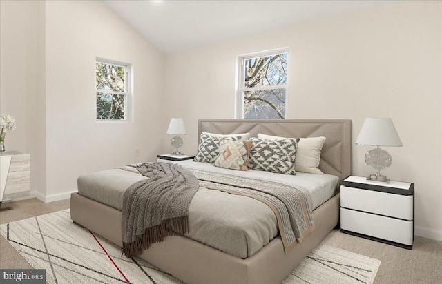 bedroom featuring vaulted ceiling, light carpet, and multiple windows