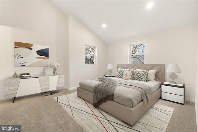 bedroom featuring light colored carpet, high vaulted ceiling, and multiple windows