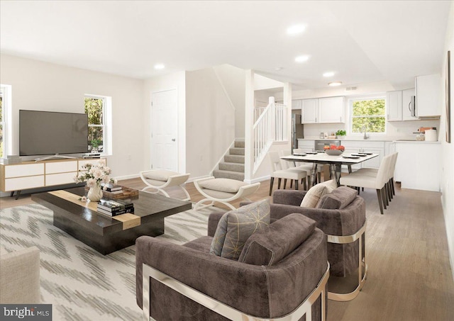 living room with light hardwood / wood-style flooring and a healthy amount of sunlight