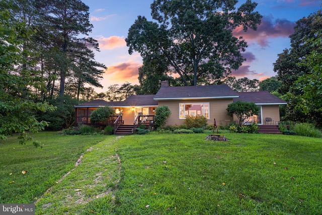 view of front of property featuring a yard and a deck