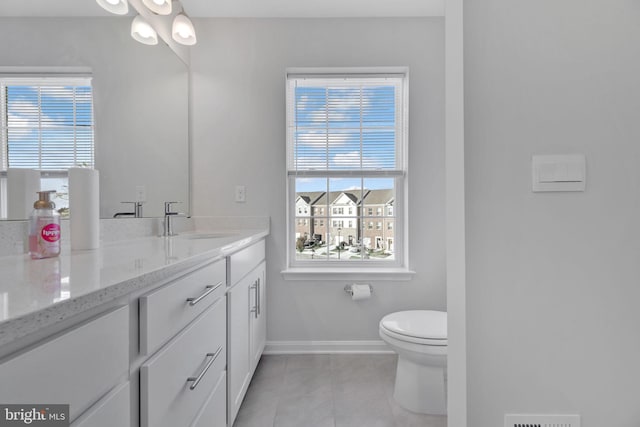 bathroom featuring toilet, vanity, tile patterned floors, and plenty of natural light