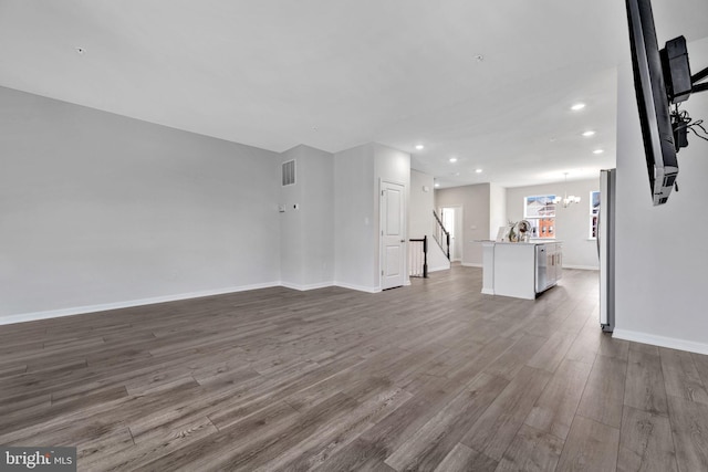 unfurnished living room featuring hardwood / wood-style floors and a chandelier