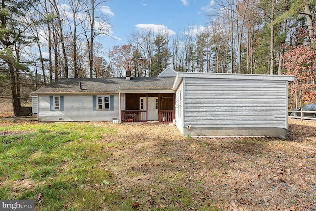 back of property featuring covered porch and a lawn