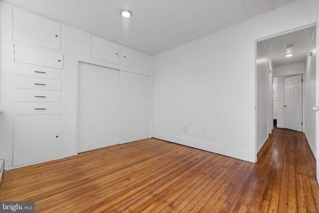 unfurnished bedroom with a closet and hardwood / wood-style floors