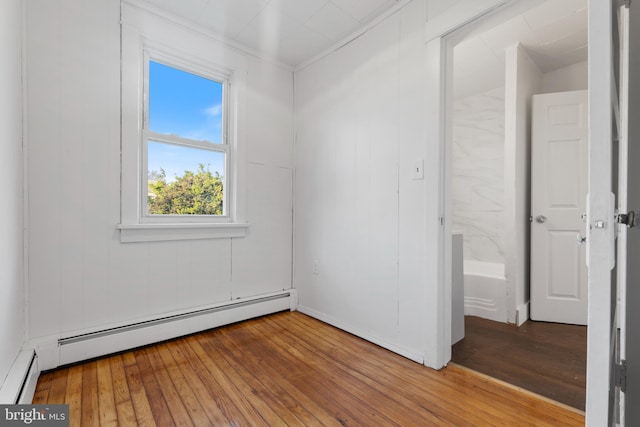 unfurnished bedroom with a baseboard radiator and hardwood / wood-style floors