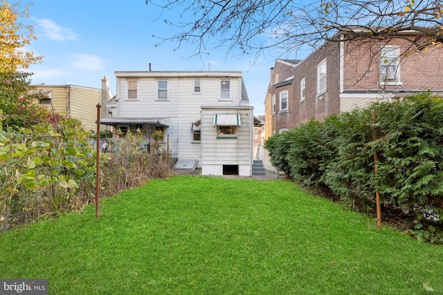 rear view of property with a yard