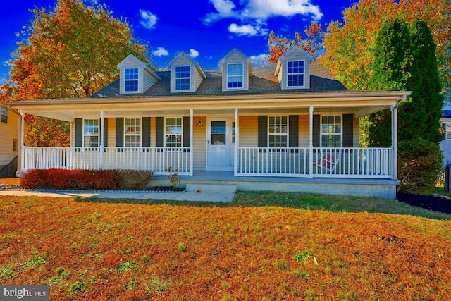 cape cod-style house with covered porch and a front lawn