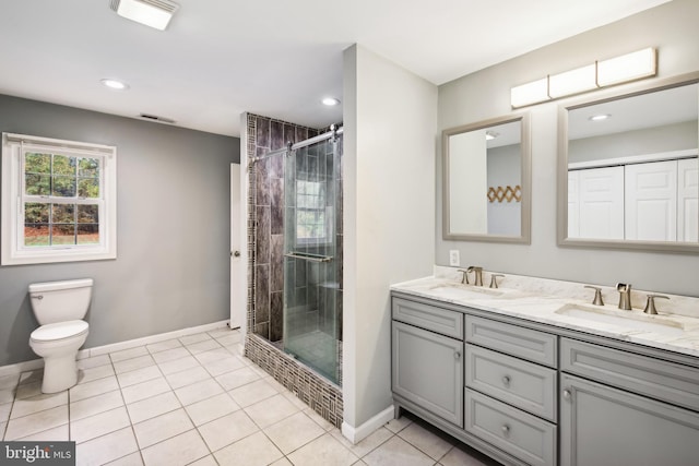 bathroom with tile patterned flooring, vanity, toilet, and a shower with shower door