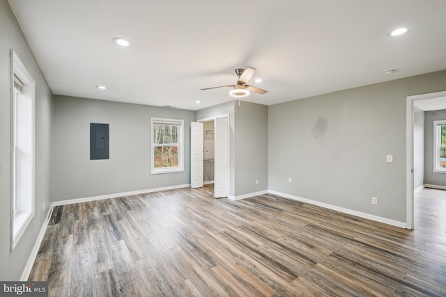 unfurnished room with hardwood / wood-style floors, ceiling fan, and electric panel