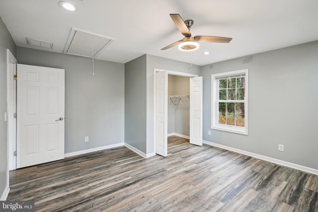 unfurnished bedroom with dark hardwood / wood-style flooring, a closet, and ceiling fan