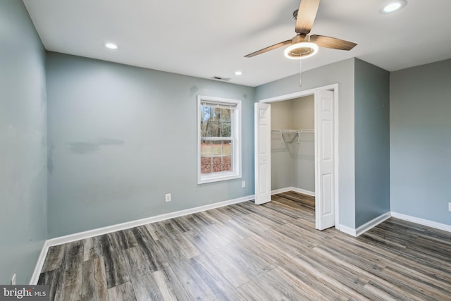 unfurnished bedroom with a closet, hardwood / wood-style floors, and ceiling fan