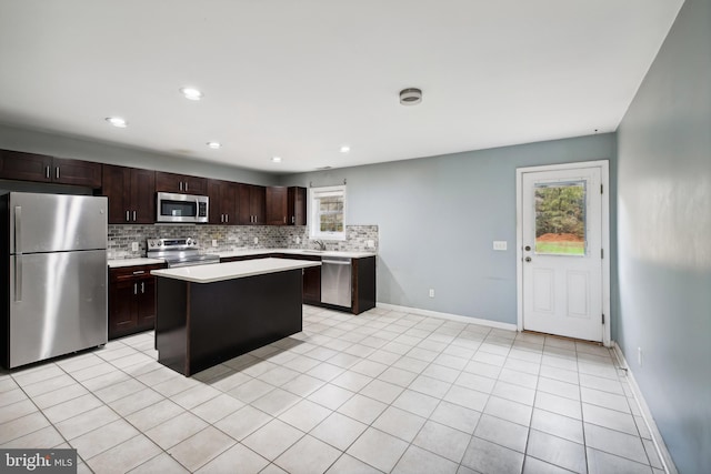 kitchen with stainless steel appliances, dark brown cabinetry, light tile patterned floors, a center island, and decorative backsplash