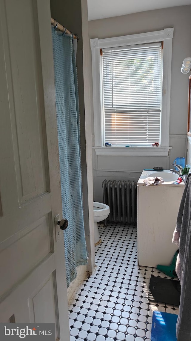 bathroom with radiator, toilet, and vanity