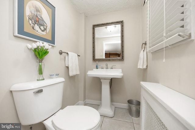 bathroom featuring toilet, a textured ceiling, and tile patterned flooring