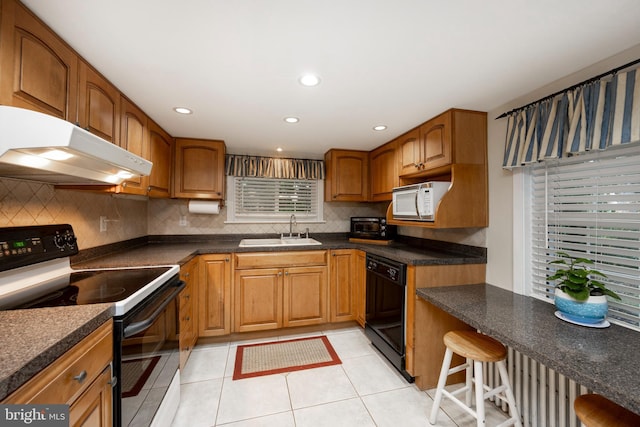 kitchen with black dishwasher, light tile patterned floors, sink, electric range oven, and a breakfast bar