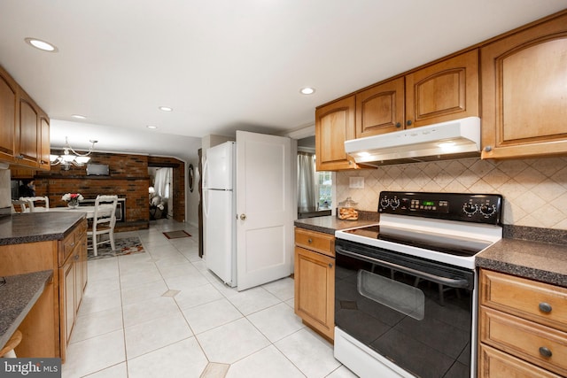 kitchen featuring white appliances, wood walls, decorative backsplash, and light tile patterned floors