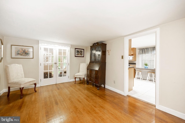 sitting room featuring light hardwood / wood-style floors and french doors