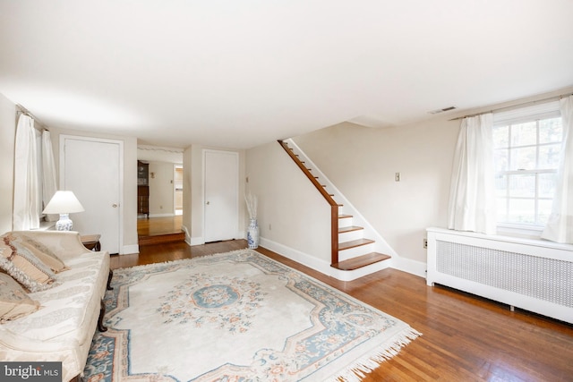 living room with dark hardwood / wood-style flooring and radiator