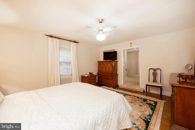 bedroom with radiator, ceiling fan, and dark hardwood / wood-style floors