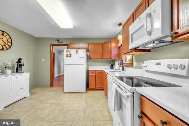 kitchen with sink, white appliances, decorative light fixtures, and light tile patterned flooring