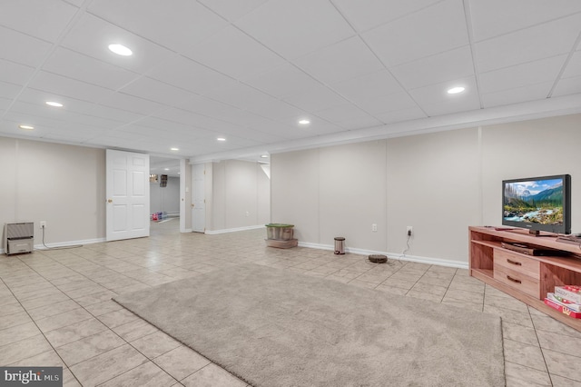 basement with a drop ceiling and light tile patterned floors