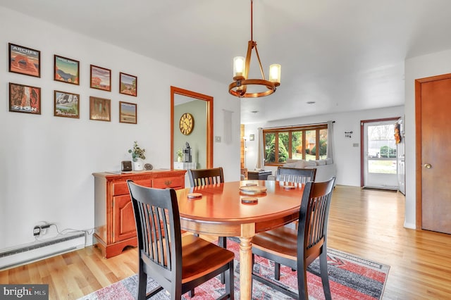 dining area with light hardwood / wood-style floors, a baseboard radiator, and a notable chandelier