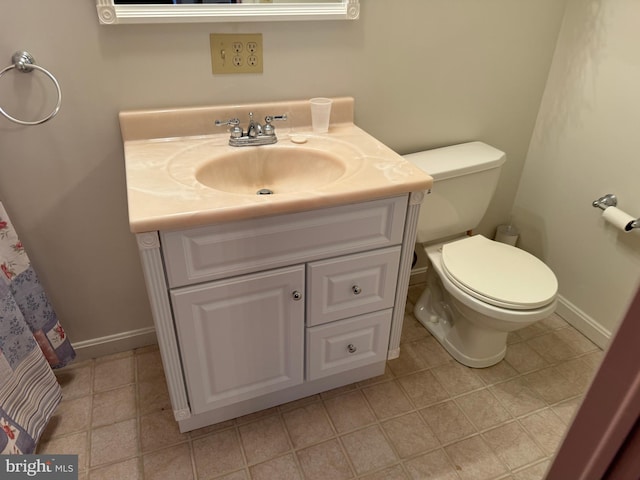 bathroom featuring toilet, vanity, and tile patterned flooring