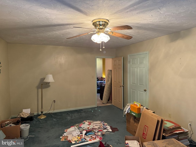 carpeted bedroom featuring ceiling fan and a textured ceiling