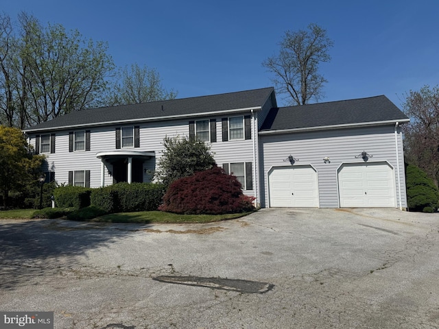 colonial-style house featuring an attached garage and driveway