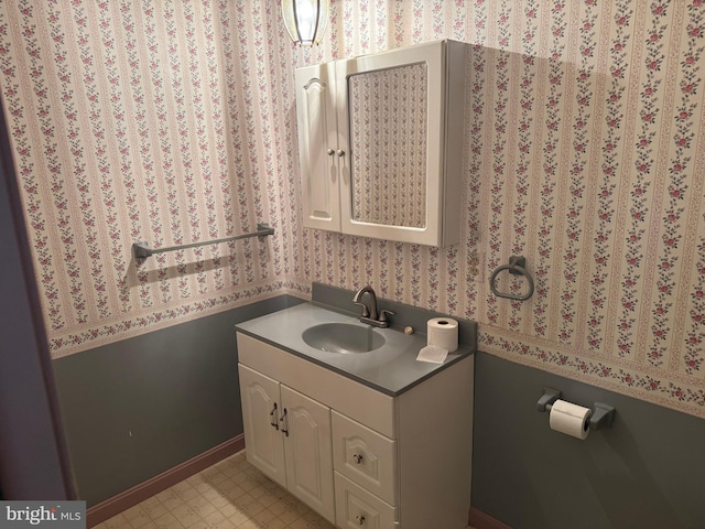 bathroom featuring tile patterned floors, vanity, and wallpapered walls