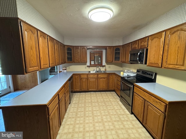 kitchen featuring light floors, brown cabinetry, and stainless steel appliances