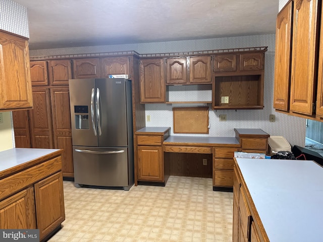kitchen featuring light floors, brown cabinets, open shelves, and stainless steel refrigerator with ice dispenser