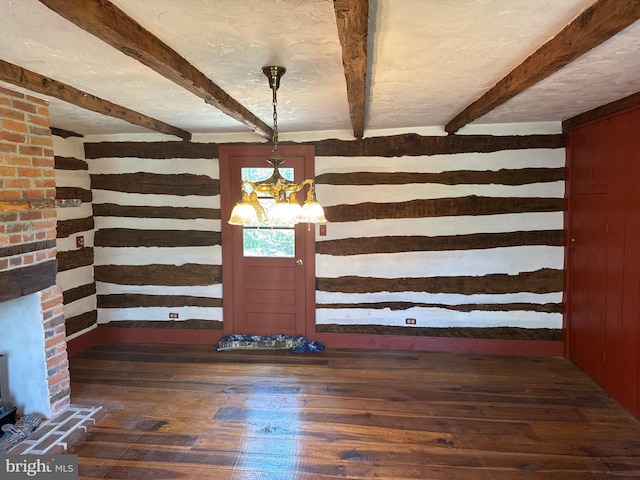 unfurnished dining area featuring dark wood-style flooring, a notable chandelier, wood walls, and beam ceiling