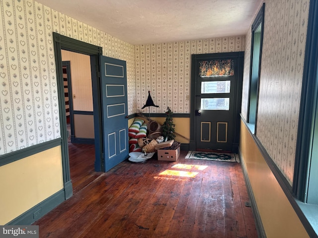 foyer entrance with hardwood / wood-style flooring, baseboards, and wallpapered walls