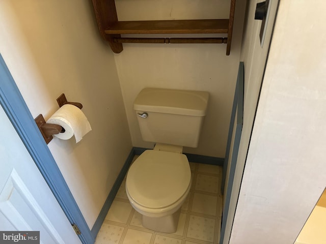 bathroom featuring toilet, baseboards, and tile patterned floors
