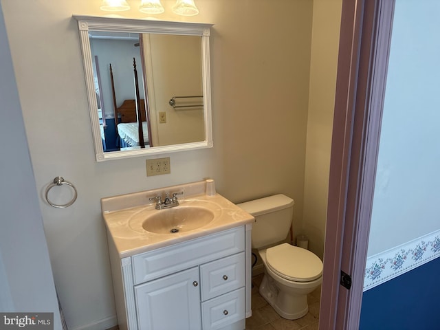half bathroom featuring vanity, toilet, and tile patterned floors