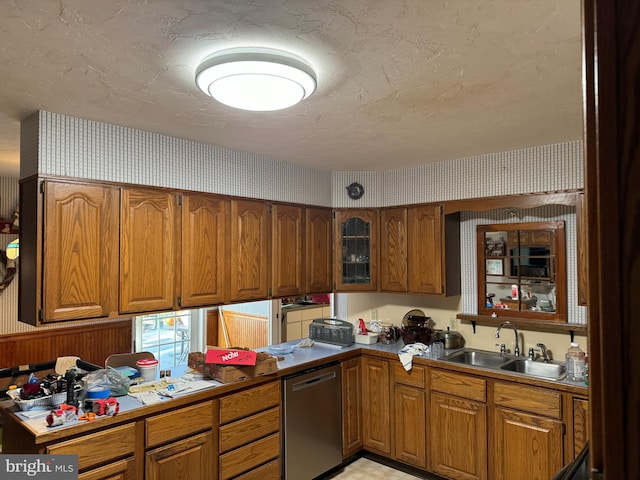 kitchen with stainless steel dishwasher, a textured ceiling, and sink