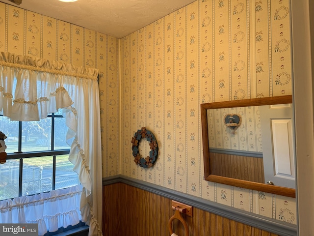 interior details featuring wooden walls and a textured ceiling