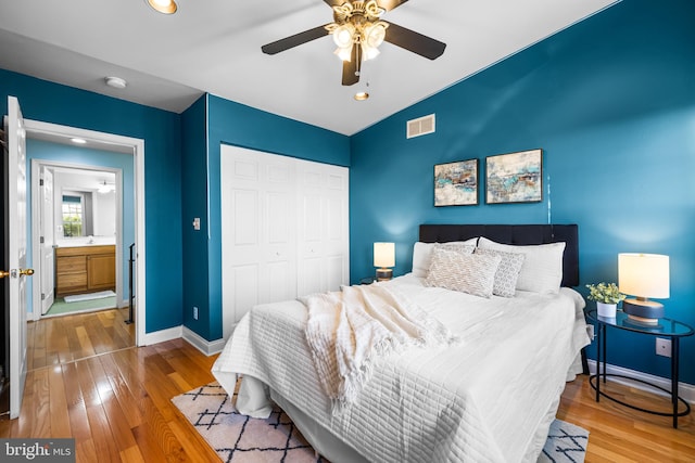 bedroom with hardwood / wood-style flooring, ceiling fan, a closet, and vaulted ceiling