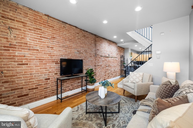 living room featuring brick wall and hardwood / wood-style flooring