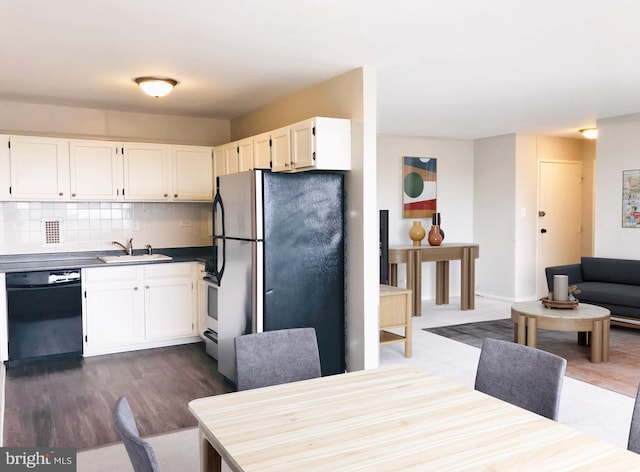 kitchen featuring dishwasher, dark wood-type flooring, stainless steel fridge, white cabinetry, and tasteful backsplash