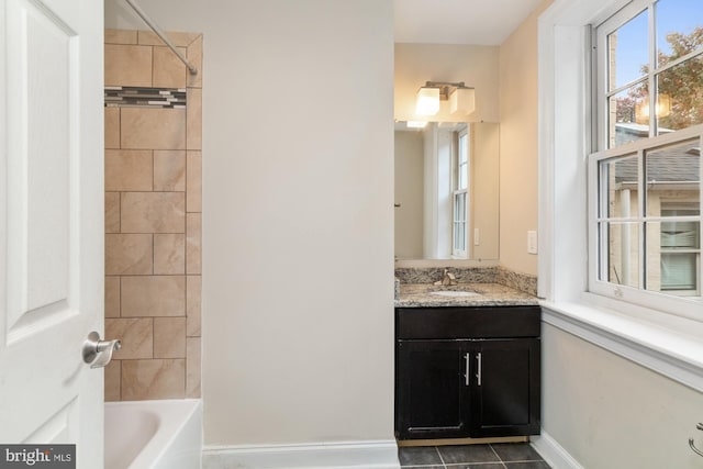 bathroom featuring tiled shower / bath, vanity, and tile patterned flooring