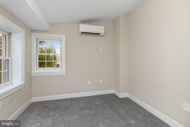 carpeted spare room featuring a wall mounted AC