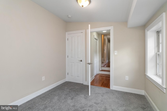 unfurnished bedroom with carpet flooring and vaulted ceiling