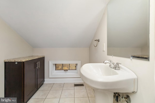 bathroom with sink, vaulted ceiling, and tile patterned floors