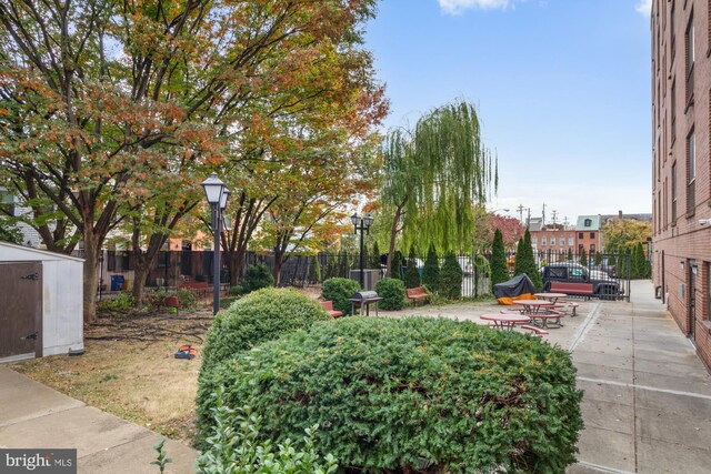 view of home's community featuring a patio and a storage shed