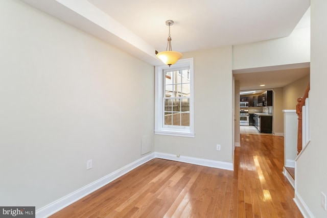 unfurnished dining area with sink and light wood-type flooring