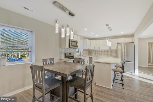 dining space featuring sink and light hardwood / wood-style flooring